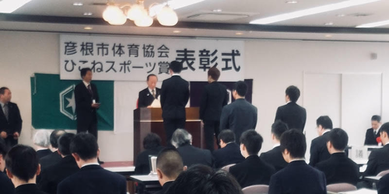 表彰式で賞状と楯をもらう二人